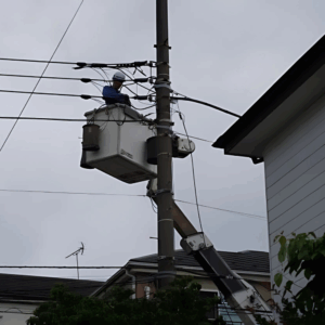 電気工事士が高所作業車で電柱の配線工事を行う様子｜電気設備の保守・点検